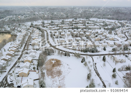 After a severe snowfall, an aerial view of a small towns hometown can be seen After a severe snowfall, an aerial view of a small towns hometown can be seen 91069454