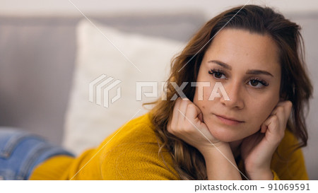 Young relaxed woman on the couch in her appartment Young relaxed woman on the couch in her appartment 91069591