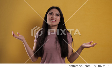 Close-up of a young pretty woman against a yellow background Close-up of a young pretty woman against a yellow background 91069592