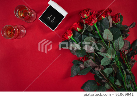 Jewelry set of golden earrings in a gift box and red roses on re Jewelry set of golden earrings in a gift box and red roses on re 91069941
