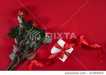 Top view fresh red rose flower and gift box on red deck with emp 91069958