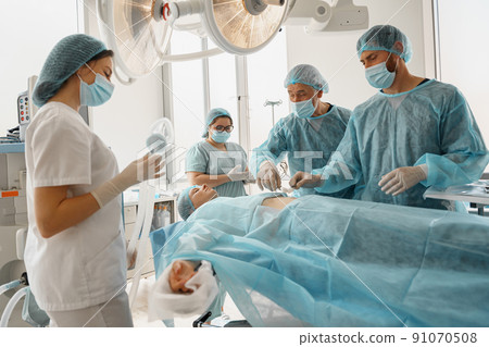 Concentrated professional surgical team working with a patient in an operation room 91070508