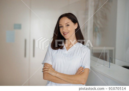 Portrait of a smiling nurse standing near the reception in a medical clinic 91070514