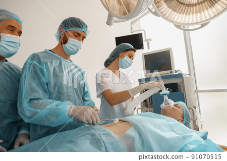 Well-trained anesthesiologist follows the patient during the surgery in clinic 91070515