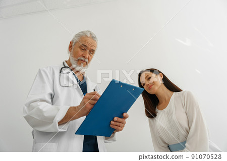 Doctor fills out the medical report form on medical care of patients during appointment Doctor fills out the medical report form on medical care of patients during appointment 91070528