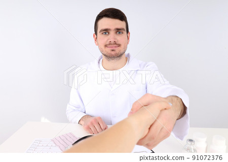 Doctor sitting at workplace and shake hand 91072376