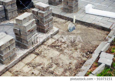View of new paving slabs and concrete blocks on summer day at construction site. Stone blocks stand 91073151