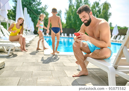 Young man resting by the swimming pool 91075582