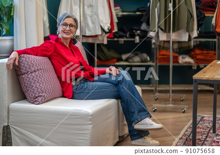 Smiling woman resolutely looking at camera sitting in atelier Smiling woman resolutely looking at camera sitting in atelier 91075658