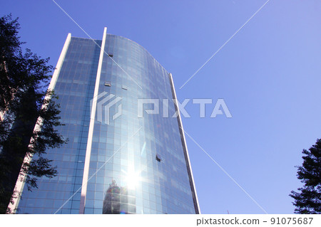 Glass-walled building in Sao Paulo, blue sky and reflected light Brazil 91075687