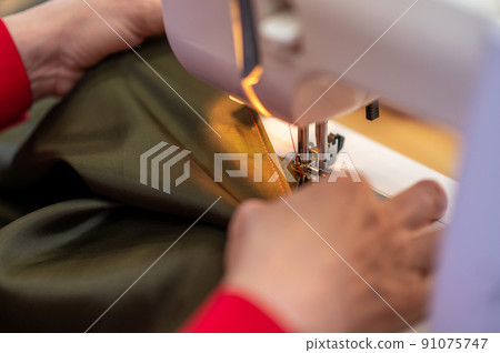 Close-up of hands holding fabric with good seam Close-up of hands holding fabric with good seam 91075747
