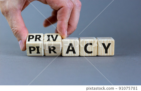 Privacy vs piracy symbol. Businessman hand turns cubes and changes the word 'piracy' to 'privacy'. Beautiful grey background, copy space. Business and privacy vs piracy concept. 91075781