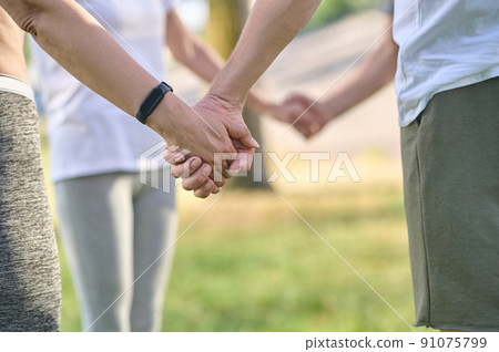Close up picture of peples hands holding each other Close up picture of peples hands holding each other 91075799