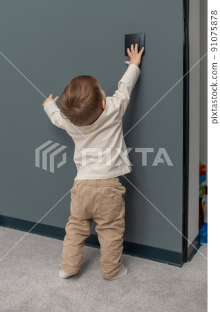 Little baby boy trying to open the locker Little baby boy trying to open the locker 91075878