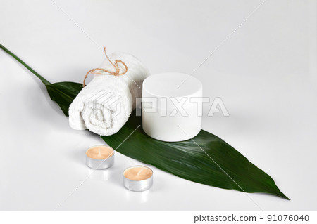 Skin care beauty treatment with jar of body moisturizer. White body lotion with big green leaf on light background. Skin care beauty treatment with jar of body moisturizer. White body lotion with big green leaf on light background. 91076040