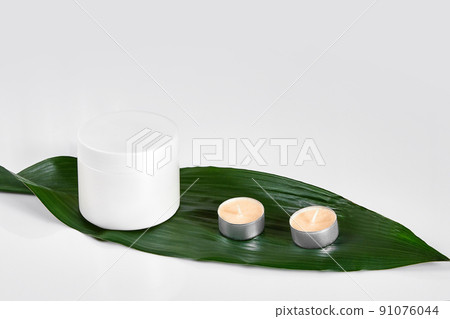 Skin care beauty treatment with jar of body moisturizer. White body lotion with big green leaf on light background. Skin care beauty treatment with jar of body moisturizer. White body lotion with big green leaf on light background. 91076044