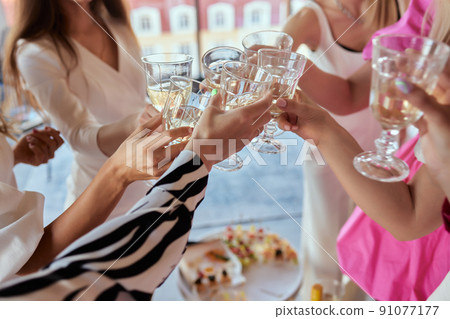 Celebration. People holding glasses of white wine making a toast. 91077177