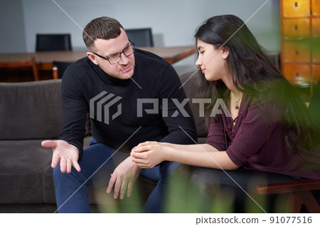 Smiling young woman visiting male therapist for session Smiling young woman visiting male therapist for session 91077516
