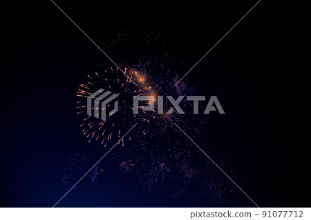 Bright orange fireworks and lots of blue and purple sparks on the background of the night sky. High quality photo 91077712