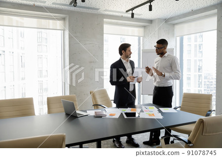 Two successful businessmen solve business in skyscraper office Two successful businessmen solve business in skyscraper office 91078745