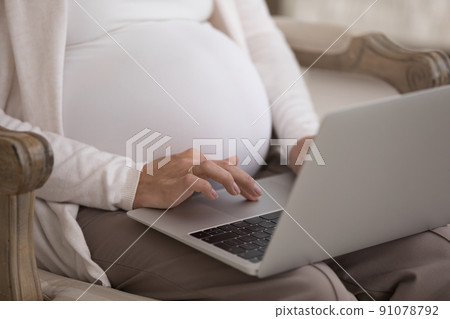 Cropped shot pregnant woman sit on armchair with laptop 91078792