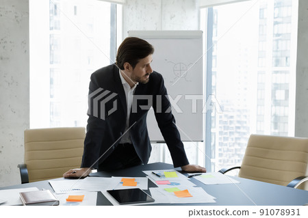 Thoughtful businessman in suit working in modern office boardroom 91078931