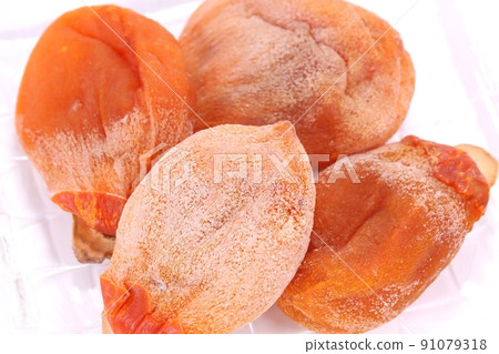 Dried persimmon, a preserved food that has been peeled and dried, sweet tea, bright background Dried persimmon, a preserved food that has been peeled and dried, sweet tea, bright background 91079318