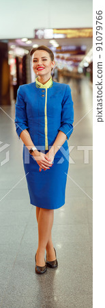 Cheerful woman stewardess standing in airport terminal 91079766