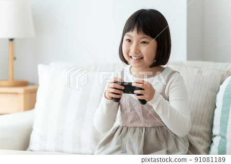 Girl playing video games in the living room 91081189