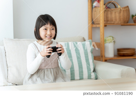 Girl playing video games in the living room 91081190