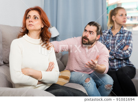 Sad mature female sitting after quarrel and daughter with boyfriend 91081694