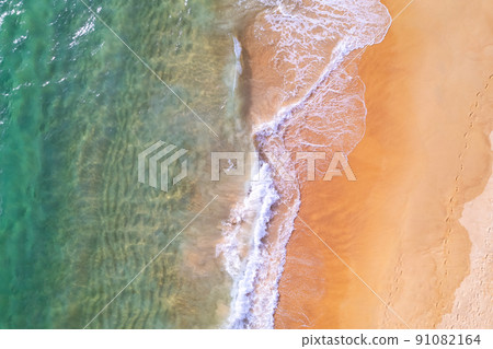 Sea background Aerial view Top down sea waves crashing on sandy beach beautiful sand sea surface in Phuket thailand Sea background Aerial view Top down sea waves crashing on sandy beach beautiful sand sea surface in Phuket thailand 91082164