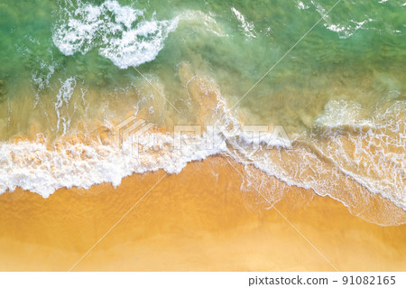 Sea background Aerial view Top down sea waves crashing on sandy beach beautiful sand sea surface in Phuket thailand Sea background Aerial view Top down sea waves crashing on sandy beach beautiful sand sea surface in Phuket thailand 91082165