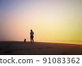 Corgi strolling along the beautiful sunrise beach 91083362