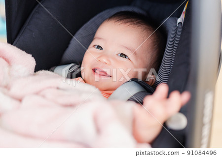 Baby smiling from a stroller 91084496