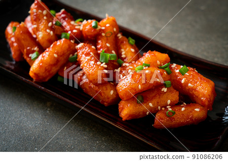 deep fried Korean rice cake (Tteokbokki) skewered with spicy sauce deep fried Korean rice cake (Tteokbokki) skewered with spicy sauce 91086206