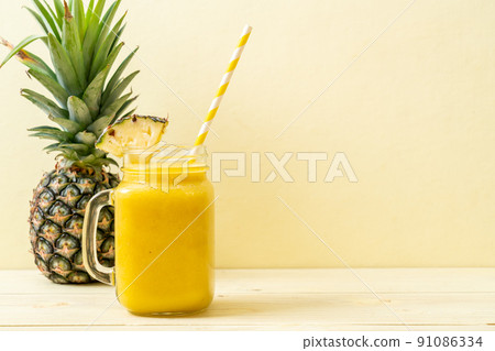 fresh pineapple smoothie glass on wood table 91086334