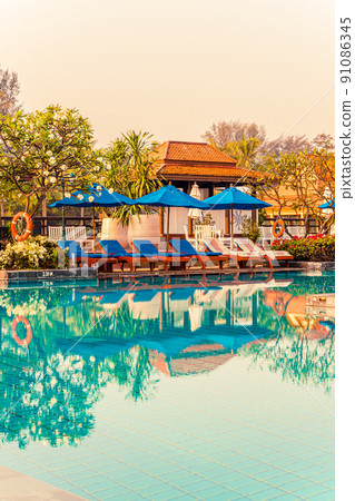 Beautiful umbrella and chair around swimming pool in hotel and resort Beautiful umbrella and chair around swimming pool in hotel and resort 91086345