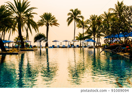 palm tree with umbrella chair pool in luxury hotel resort at sunrise times palm tree with umbrella chair pool in luxury hotel resort at sunrise times 91089094
