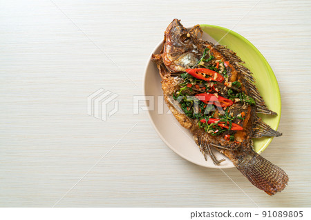 Fried Tilapia Fish with Basil chili garlic sauce Fried Tilapia Fish with Basil chili garlic sauce 91089805