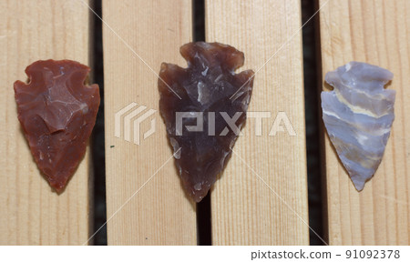 Native American Arrowhead Collection on Wooden Background 91092378