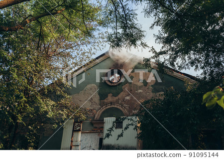 A fire on the roof of an old abandoned building 91095144
