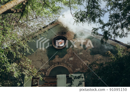 A fire on the roof of an old abandoned building 91095150