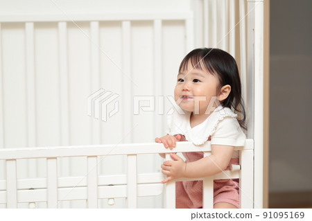 1歲小女孩在嬰兒床上玩耍 91095169