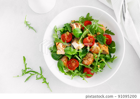 Grilled salmon salad with tomato and salad mix. Top view 91095200