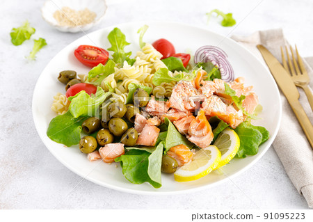 Grilled salmon salad with fresh lettuce, tomatoes, green olives, red onion and pasta. Healthy food, diet Grilled salmon salad with fresh lettuce, tomatoes, green olives, red onion and pasta. Healthy food, diet 91095223