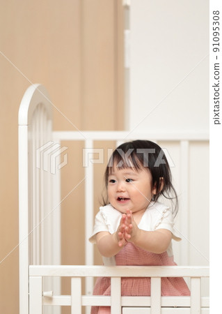 1歲小女孩在嬰兒床上玩耍 91095308