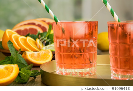 Two glasses of summer lemonade cocktail on tray, mint, fresh fruits  91096418