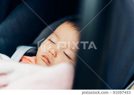 Baby sleeping comfortably in a stroller 91097483