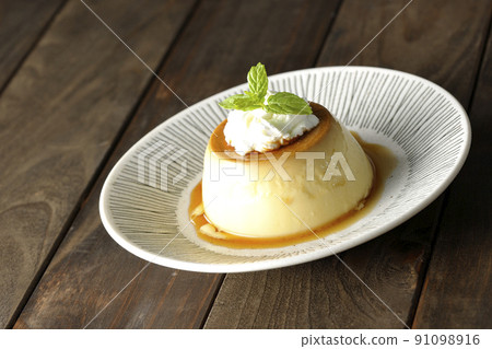 Old-fashioned retro pudding with mint leaves and fresh cream served on a flat plate Old-fashioned retro pudding with mint leaves and fresh cream served on a flat plate 91098916